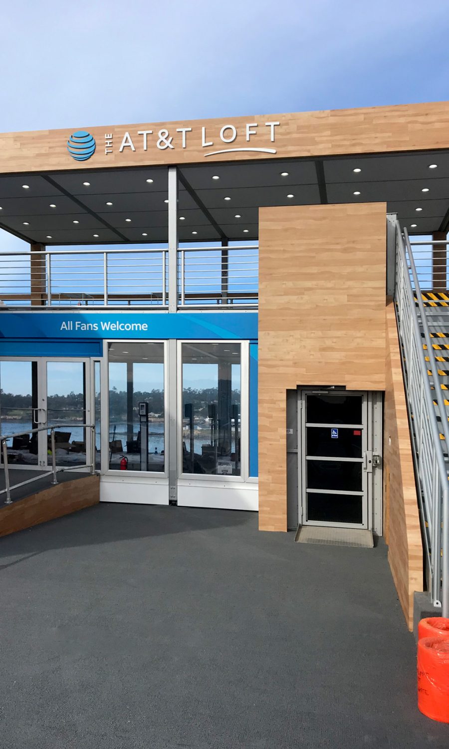 12' ADA Lift Rental at an entranceway for the Pebble Beach Farmer's Insurance Open. Shown next to stairs in an enclosure designed to fit into the design of the event space