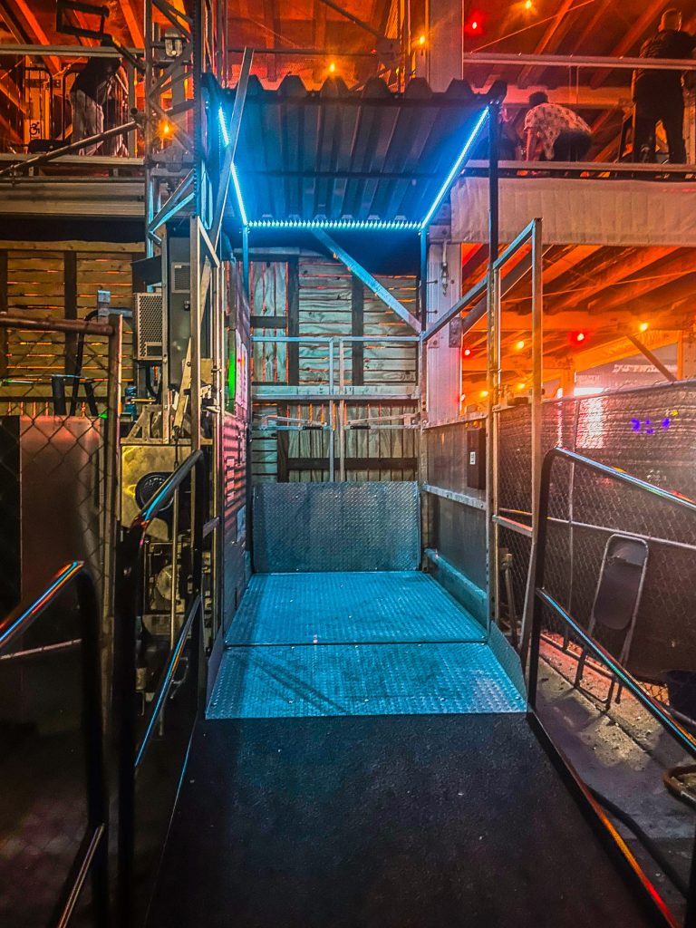 ADA Lift Rentals' transport platform amidst colorful lighting at night at the Louder than Life festival.
